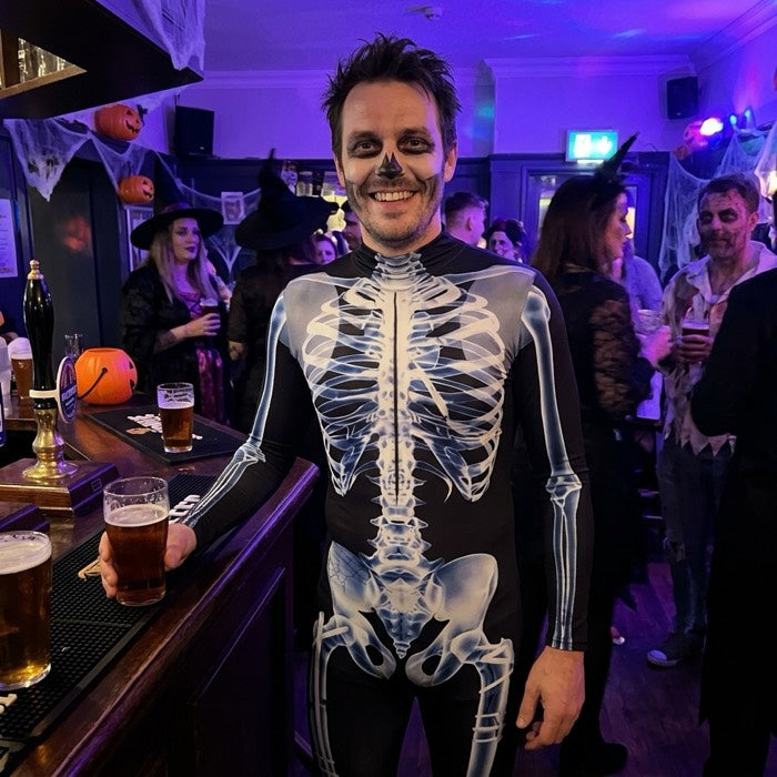 Man in a skeleton print catsuit at a pub on Halloween night